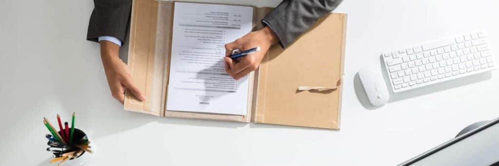 person filling out resume at desk